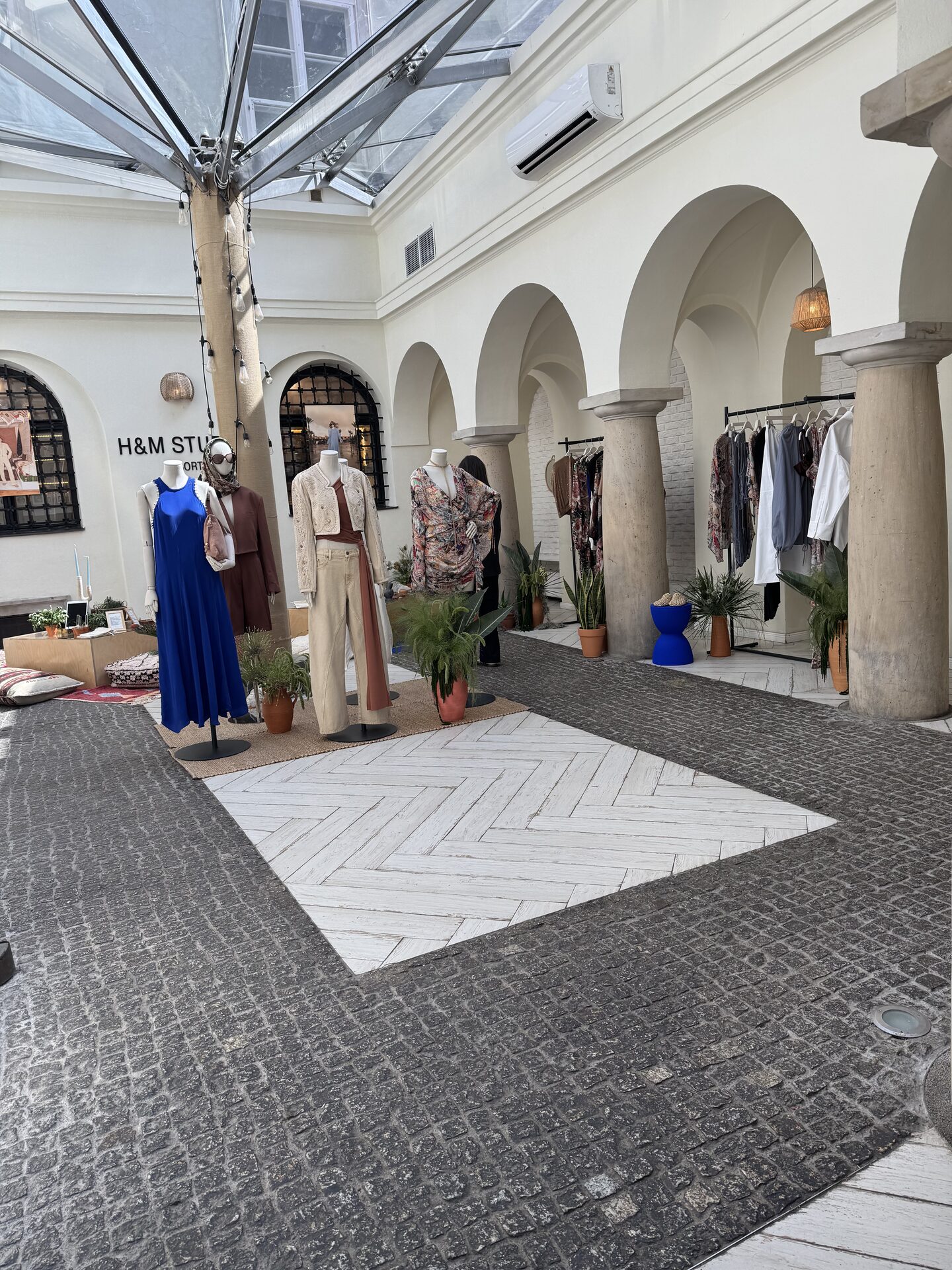 Prezentacja mody na patio z manekinami pod szklanym świetlikiem